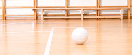 Volleyball ball and white line on wooden court. Horizontal education and sport poster, greeting cards, headers, websiteの写真素材