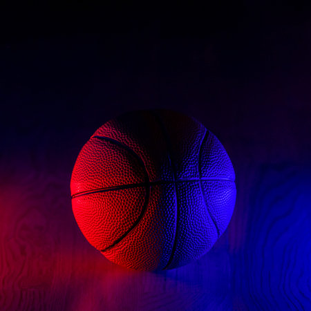 Basketball ball isolated on dark background. Blue neon banner. Horizontal sport theme poster,...