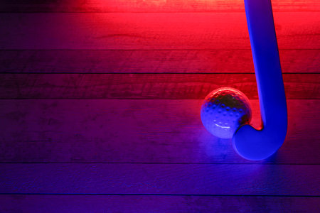 Field hockey and ball on hardwood court floor with neon lighting. Blue neon banner. Horizontal sport...