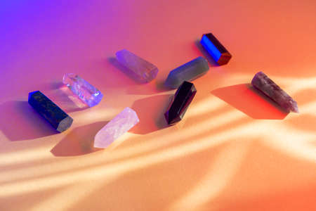 Healing chakra crystals with colorful light on beige background. Meditation, reiki and spiritual healing conceptの写真素材