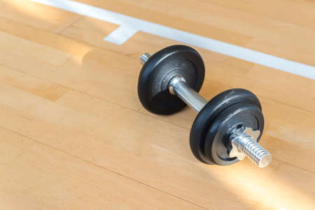 Dumbbell on wooden surface. Concept of rehabilitation and sport training equipmentの写真素材