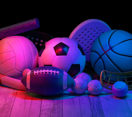 Sports equipment, rackets and balls on hardwood court floor with neon light background. Horizontal education and sport poster, greeting cards, headers, websiteの写真素材