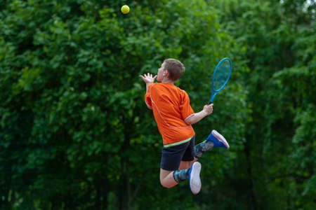Child with tennis racket on tennis court. Training for young kid, healthy children. Horizontal sport theme poster, greeting cards, headers, website and appの写真素材