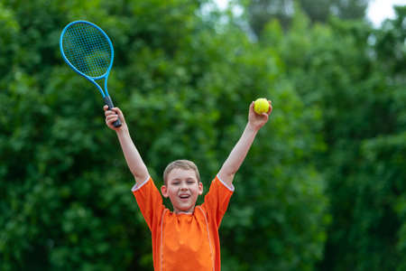 Child with tennis racket on tennis court. Training for young kid, healthy children. Horizontal sport theme poster, greeting cards, headers, website and appの写真素材