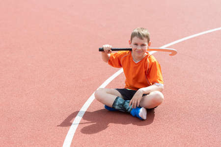 Boy playing field hockey with stick. Concept of a sports lifestyle, training, camp, leisure, vacation. Horizontal sport theme poster, greeting cards, headers, website and appの写真素材