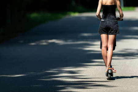 Woman riding an electric scooter. Horizontal eco theme poster, greeting cards, headers, website and appの写真素材