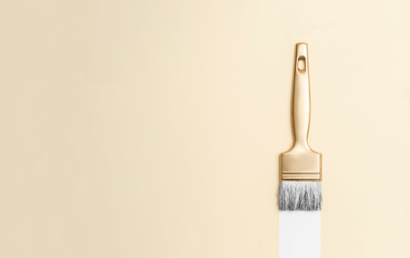 Gold color paintbrush on beige background. Horizontal creative theme poster, greeting cards, headers, website and appの写真素材
