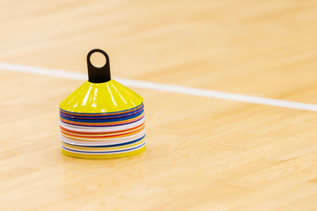 Training cones on hardwood court floor. Basketball, futsal, handball and volleyball practice. Game equipment Horizontal sport theme poster, greeting cards, headers, website and appの写真素材
