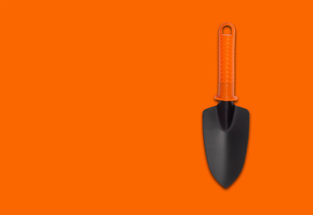 Hand plant shovel isolated on orange backgroundの写真素材