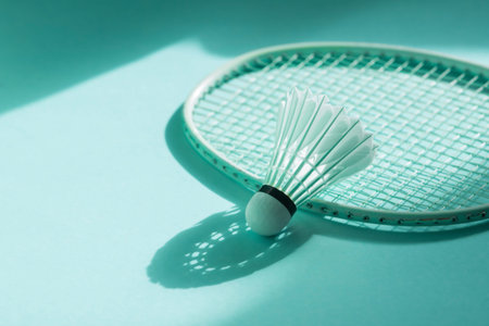 Badminton racket and shuttlecock on mint color background. Horizontal sport theme poster, greeting...