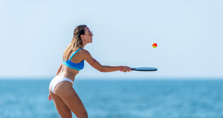 Woman playing beach tennis on a beach. Professional sport concept. Horizontal sport theme poster, greeting cards, headers, website and appの写真素材