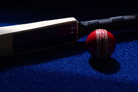 Cricket bat and red ball on blue background. Horizontal sport theme poster, greeting cards, headers, website and appの写真素材