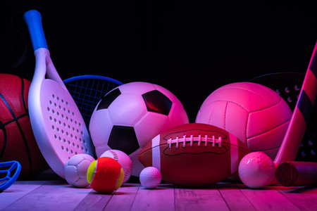 Sports equipment, rackets and balls on hardwood court floor with neon light background. Horizontal education and sport poster, greeting cards, headers, websiteの写真素材