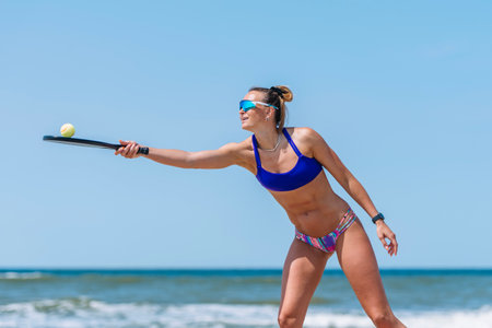 Professional woman playing beach tennis on a beach. Professional sport concept. Horizontal sport theme poster, greeting cards, headers, website and appの写真素材