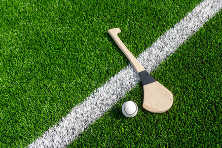 Hurling bat and sloitar on green grass. Horizontal sport theme poster, greeting cards, headers, website and appの写真素材