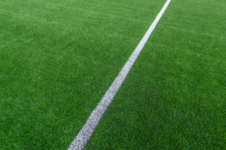 Green synthetic grass sports field with white line shot from above. Soccer, hurling, lacrosse,...
