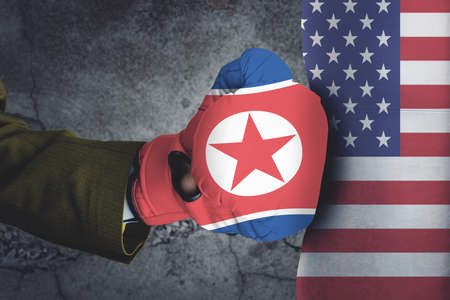 Conflict, close up of two fists hitting each other over dramatic concreate background , USA and North Korea conflict conceptの写真素材