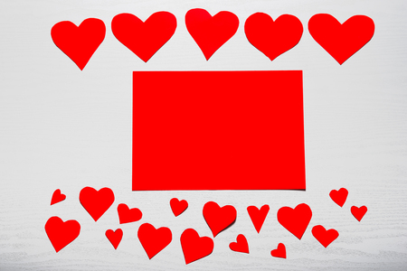 Wooden white background with red hearts and red leaf paper. The concept of Valentine's Day.の写真素材