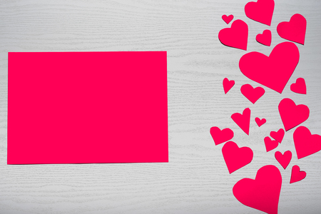 Wooden white background with red hearts and red leaf paper. The concept of Valentine's Day.の写真素材