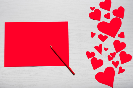 Wooden white background with red hearts and red leaf paper. The concept of Valentine's Day.の写真素材