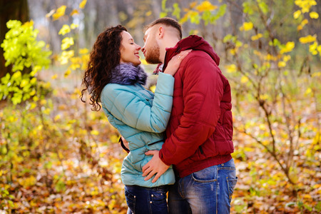 Portrait of young loving couple kissing in autumn parkの写真素材