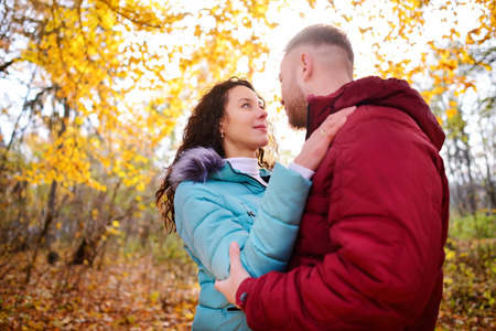 Portrait of young loving couple kissing in autumn parkの写真素材