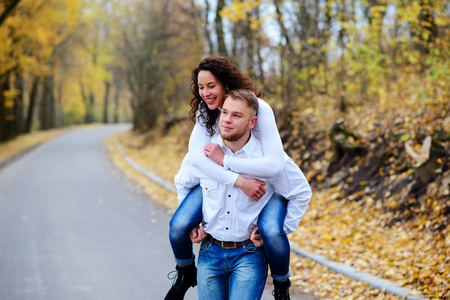 Lovers walking hand in hand in autumn parkの写真素材