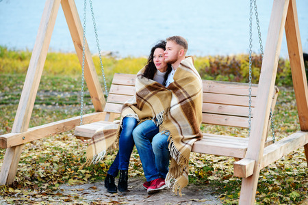 Amorous couple on romantic date on swings outdoor ,autumnの写真素材