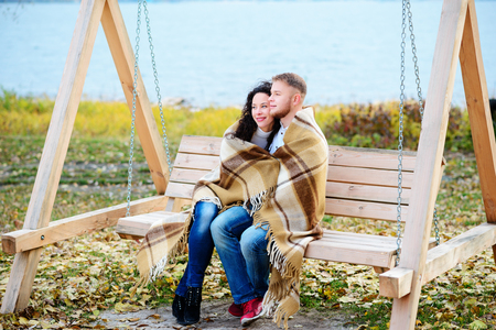 Amorous couple on romantic date on swings outdoor ,autumnの写真素材