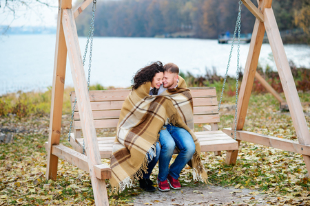 Amorous couple on romantic date on swings outdoor ,autumnの写真素材