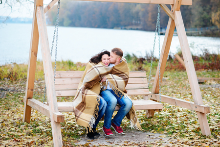 Amorous couple on romantic date on swings outdoor ,autumnの写真素材