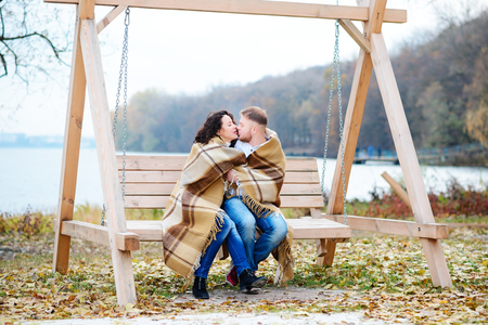 Amorous couple on romantic date on swings outdoor ,autumnの写真素材
