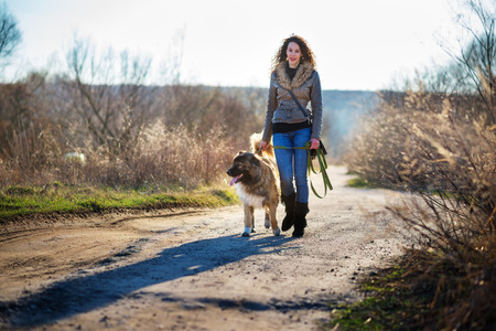 Young woman playing with Caucasian shepherd in a delightful spring dayの写真素材