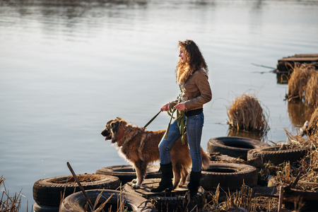 Young woman playing with Caucasian shepherd in a delightful spring dayの写真素材