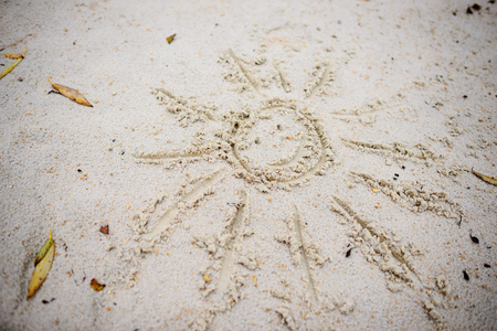 The symbol of the sun drawn in the sand on a cloudy autumn dayの写真素材