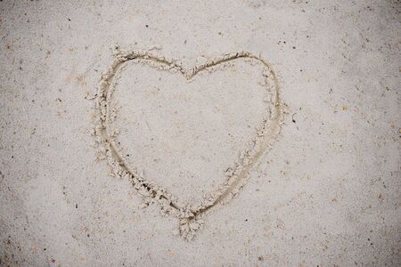 Heart, drawn on the beach sand. heart symbol on the sand washed by the sea wave.の写真素材