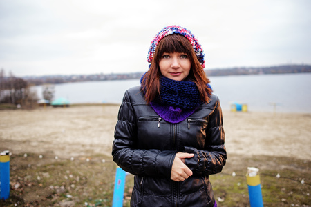 Portrait of young beautiful woman outdoor - standing on seaside and holding waving fabric scarf in her arms on windの写真素材