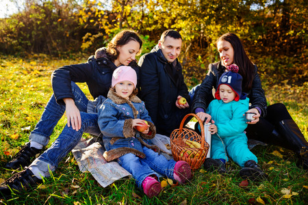 Young family of four having picnic at meadow at summer dayの写真素材