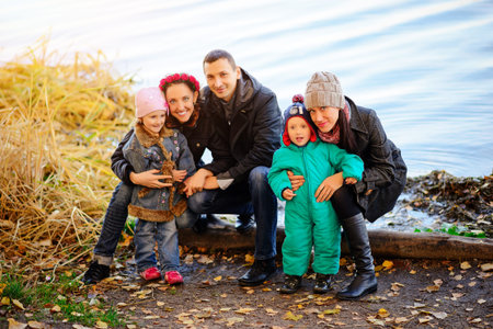 Parents look at children in autumn park, A lovely sunny day