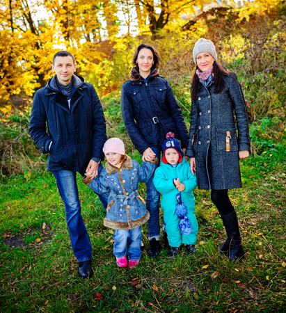 Young family, parents with small children in golden autumnの写真素材
