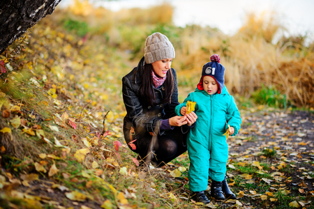 Mother with son in autumn peach garden, lovely sunny dayの写真素材