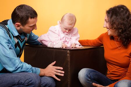 Parents and daughter, on an orange backgroundの写真素材