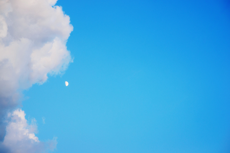 Clear Blue sky with clouds and moonの写真素材