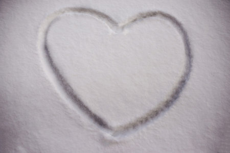 The symbol of the heart, painted on the fresh white snowの写真素材