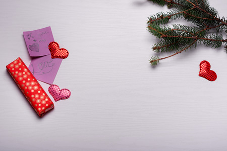 Wooden white background with a branch of pine and three hearts. The concept for Valentine's Dayの写真素材