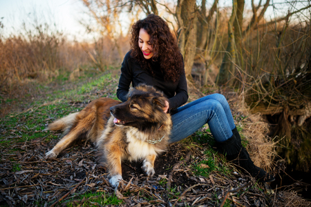 Young woman playing with Caucasian shepherd in a delightful spring dayの写真素材