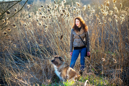 Young woman playing with Caucasian shepherd in a delightful spring dayの写真素材