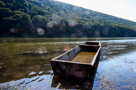an old boat full of water, the shore of the autumn riverの写真素材