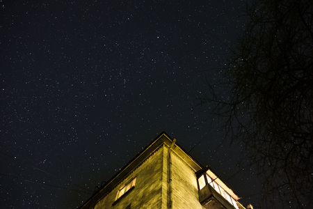 Clouds passing in the moon light by over a forest and on a night sky full of stars.の写真素材