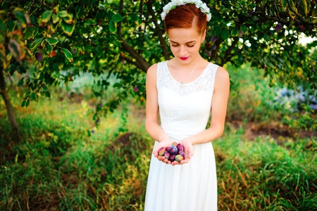 beautiful bride holding a lot of cream, a wonderful summer day.の写真素材